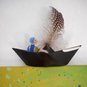 Eine gebastelte Figur sitzt in einem Papierboot.