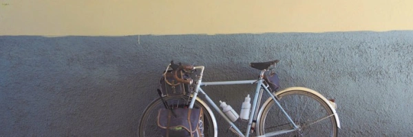 Ein Fahrrad lehnt an einer Wand, die mit Skulpturen, von Wappen und einem Löwen, geschmückt ist