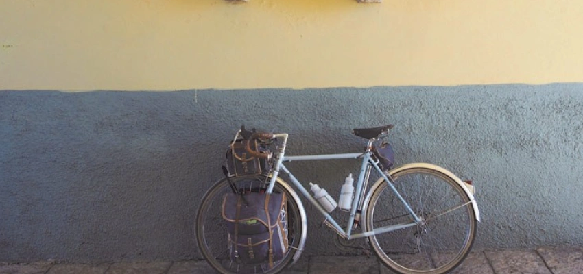 Ein Fahrrad lehnt an einer Wand, die mit Skulpturen, von Wappen und einem Löwen, geschmückt ist