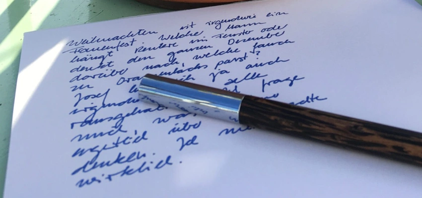 Ein Füller liegt auf einem beschriebenen Papierbogen.