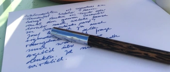 Ein Füller liegt auf einem beschriebenen Papierbogen.