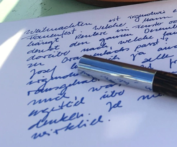 Ein Füller liegt auf einem beschriebenen Papierbogen.