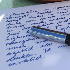 Ein Füller liegt auf einem beschriebenen Papierbogen.