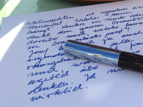 Ein Füller liegt auf einem beschriebenen Papierbogen.