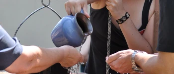 Ein Wasserkrug wird über offenen Händen ausgegossen.