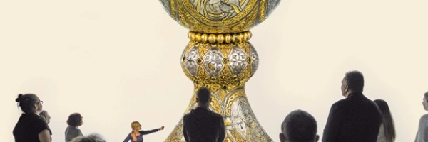 Menschen sind um einen großen goldenen Kelch versammelt.
