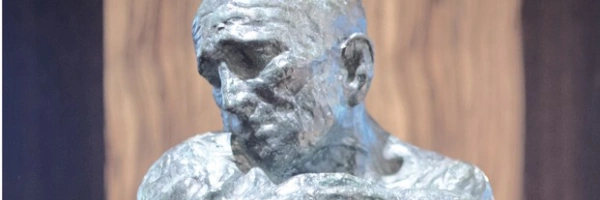 Eine Skulptur zeigt einen Menschen, der einen anderen umarmt, der alle Kräfte verloren zu haben scheint.