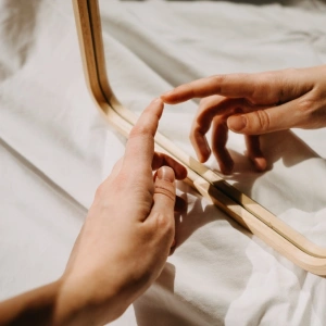 Eine Hand berührt ihr Spiegelbild, in einem Spiegel.