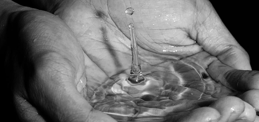 Wasser sammelt sich in einer Schale aus Händen.