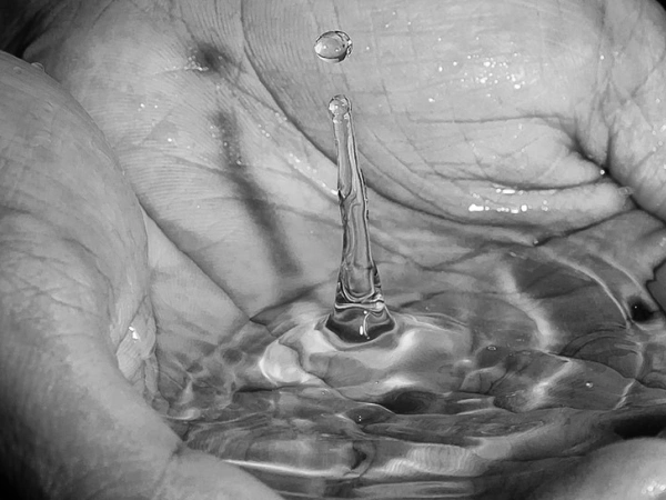 Wasser sammelt sich in einer Schale aus Händen.