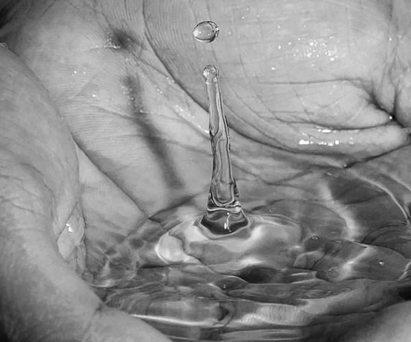 Wasser sammelt sich in einer Schale aus Händen.