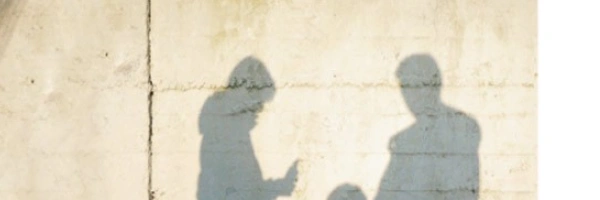 Eine Familie wird als Schatten auf eine Betonwand geworfen.