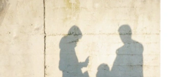 Eine Familie wird als Schatten auf eine Betonwand geworfen.
