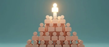 Eine Menschenpyramide. Der Mensch an der Spitze leuchtet.