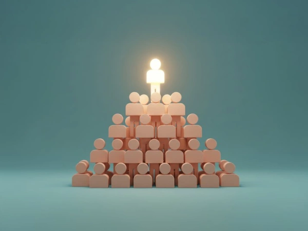 Eine Menschenpyramide. Der Mensch an der Spitze leuchtet.