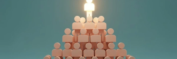Eine Menschenpyramide. Der Mensch an der Spitze leuchtet.