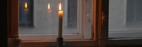Brennende Kerze auf einem Fensterbrett