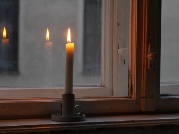 Brennende Kerze auf einem Fensterbrett