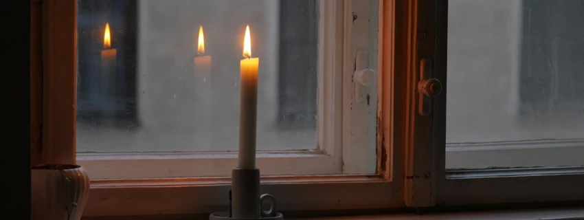Brennende Kerze auf einem Fensterbrett