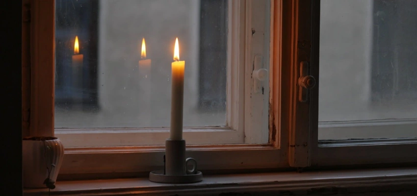 Brennende Kerze auf einem Fensterbrett
