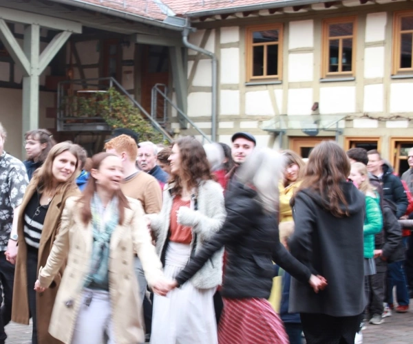 Menschen tanzen im REZ-Hof