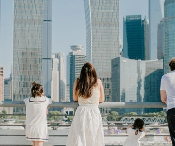Familie steht an einem Geländer vor einer Skyline