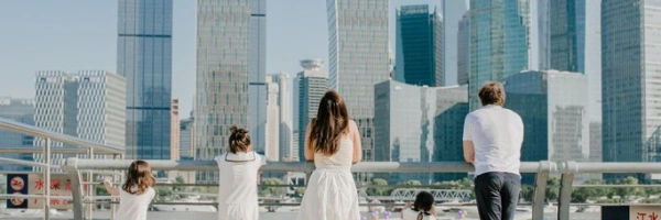 Familie steht an einem Geländer vor einer Skyline