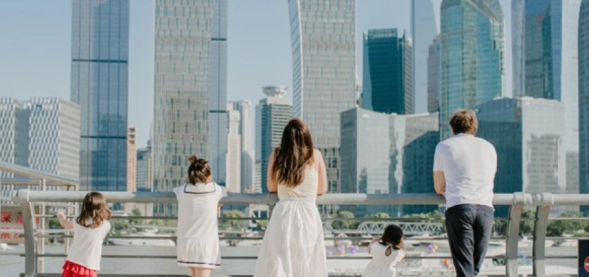 Familie steht an einem Geländer vor einer Skyline