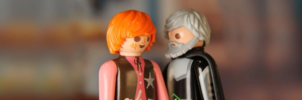 Zwei Playmobil-Figuren, eine jung, die andere alt, stehen sich sich gegenüber