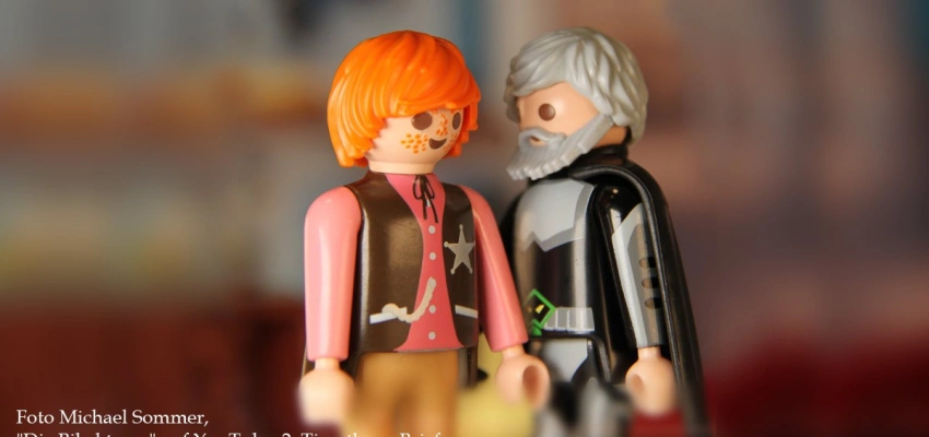 Zwei Playmobil-Figuren, eine jung, die andere alt, stehen sich sich gegenüber