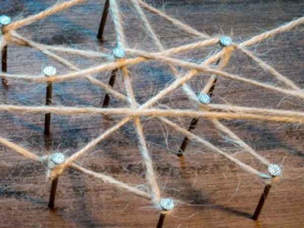auf Nägeln in holz ein Netz aus Strick geschlungen