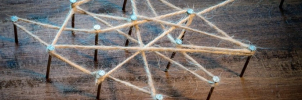 auf Nägeln in holz ein Netz aus Strick geschlungen