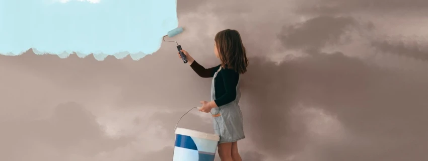 Kind streicht eine graue Wolkenwand mit himmelblauer Farbe
