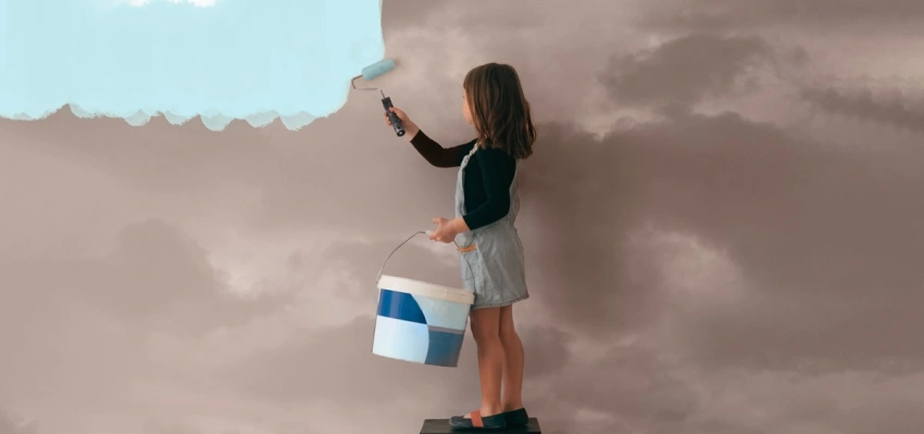 Kind streicht eine graue Wolkenwand mit himmelblauer Farbe
