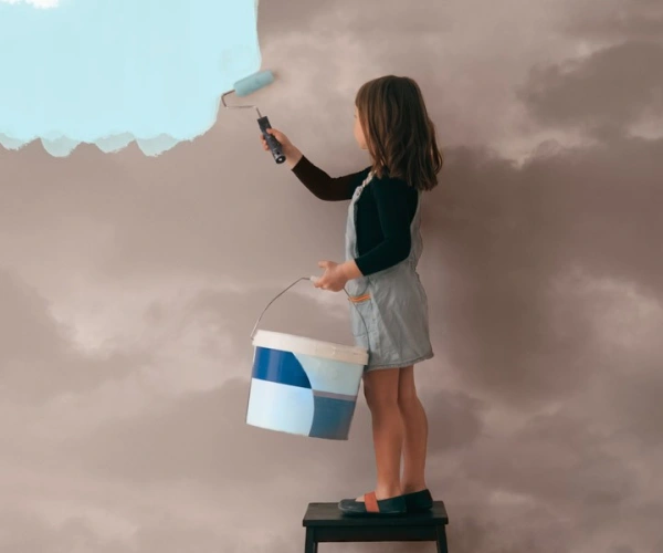 Kind streicht eine graue Wolkenwand mit himmelblauer Farbe