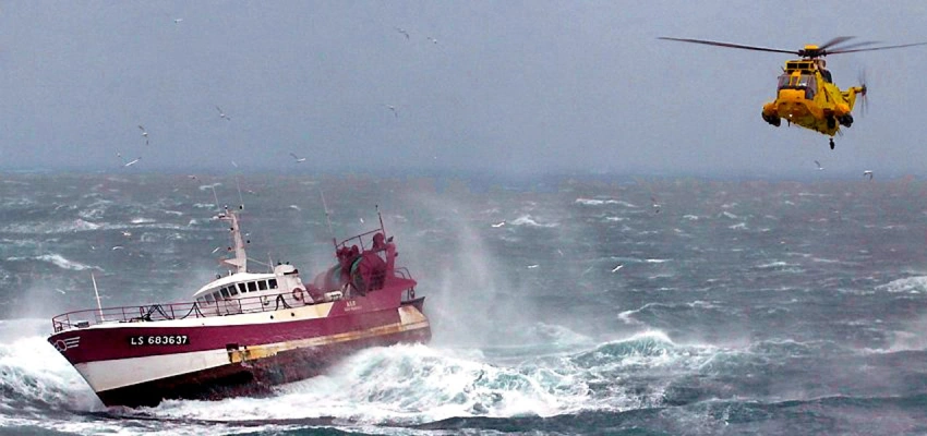 Schiff in Seenot. Rettungshubschrauber schwebt über der See