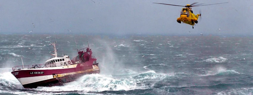 Schiff in Seenot. Rettungshubschrauber schwebt über der See