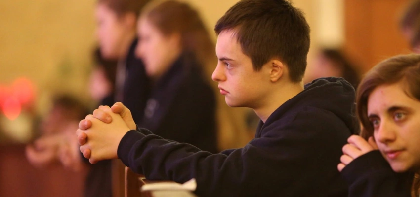 Betende Menschen in einer Kirchenbank.