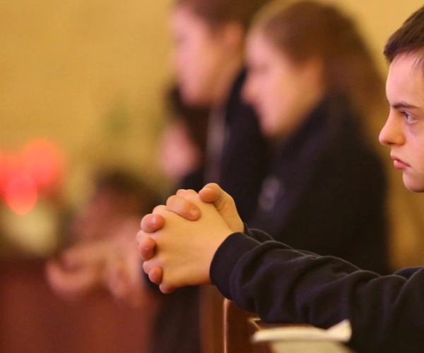 Betende Menschen in einer Kirchenbank.