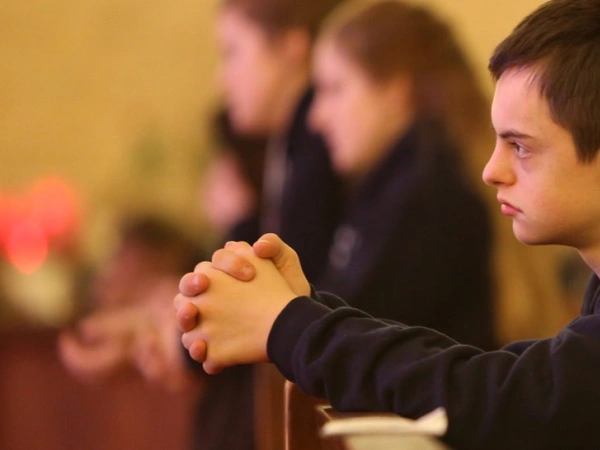 Betende Menschen in einer Kirchenbank.