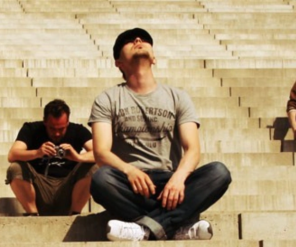 Menschen sitzen auf einer großen Treppe und schauen nach oben in den Himmel