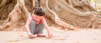 Tief verwurzelt. Wie Kinder an Krisen wachsen können. Bild von einem spielenden Kind.