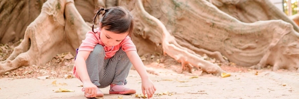 Tief verwurzelt. Wie Kinder an Krisen wachsen können. Bild von einem spielenden Kind.