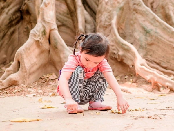 Tief verwurzelt. Wie Kinder an Krisen wachsen können. Bild von einem spielenden Kind.