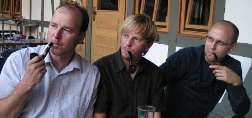 Drei pfeiferauchende Männer genießen ein entspanntes Miteinander