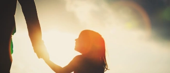 Wir setzten auf Hoffnung. Unser Weg zum Elternsein. Bild eines jungen Mädchens welches die Hand ihres Elternteils hält.